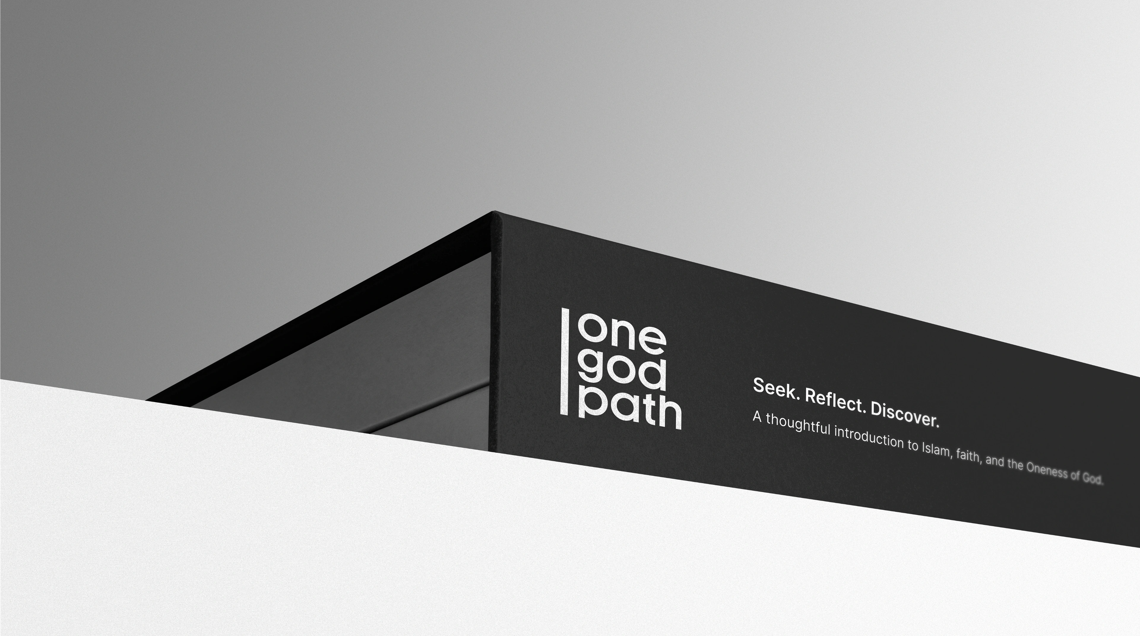 A dark matte signage fascia wraps a building corner against a pale sky, carrying the one god path logo and the Seek. Reflect. Discover. tagline.