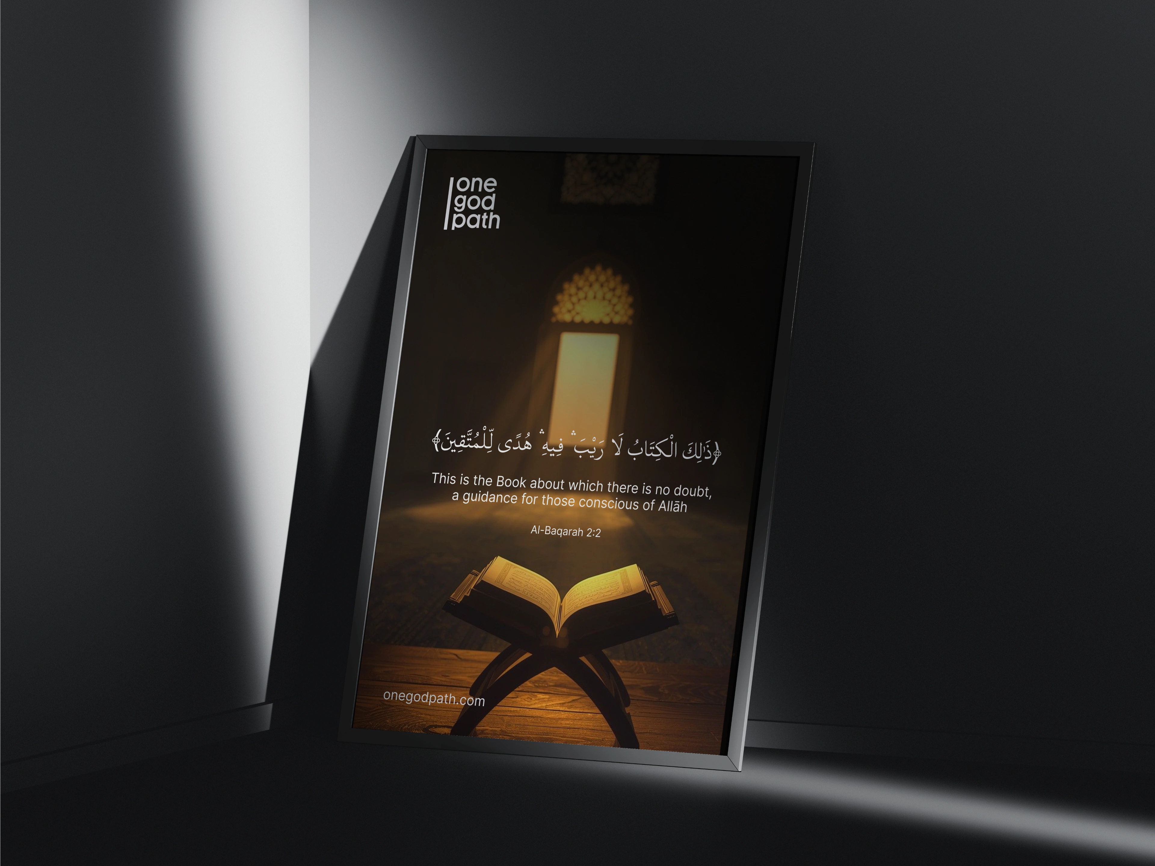 A framed poster leans in a dark corner under a shaft of light, showing the one god path logo with Al-Baqarah 2:2 in Arabic and English.