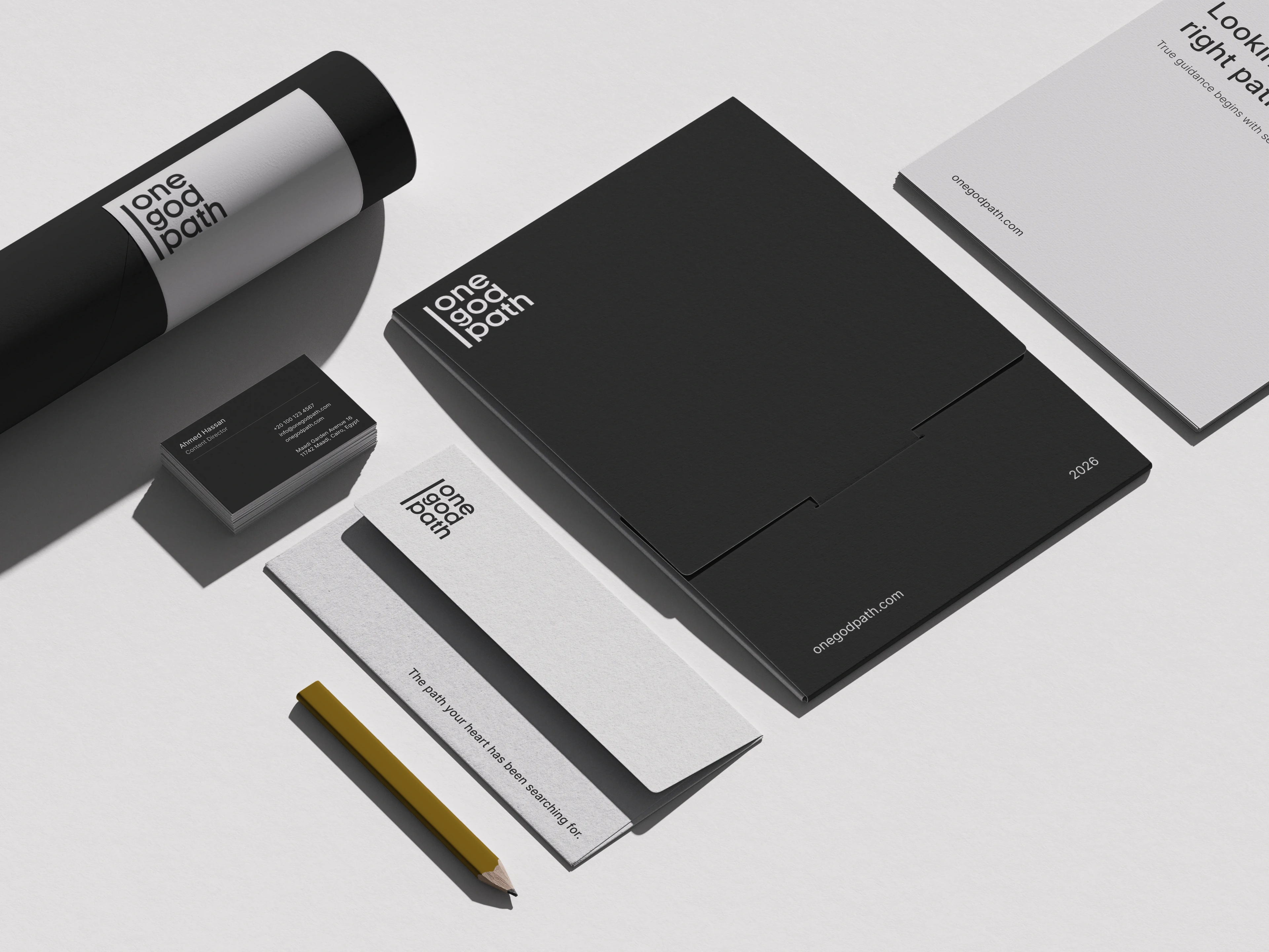 Branded stationery is arranged on light grey: a poster tube, business cards, a folder, letterhead, a booklet and a gold pencil.