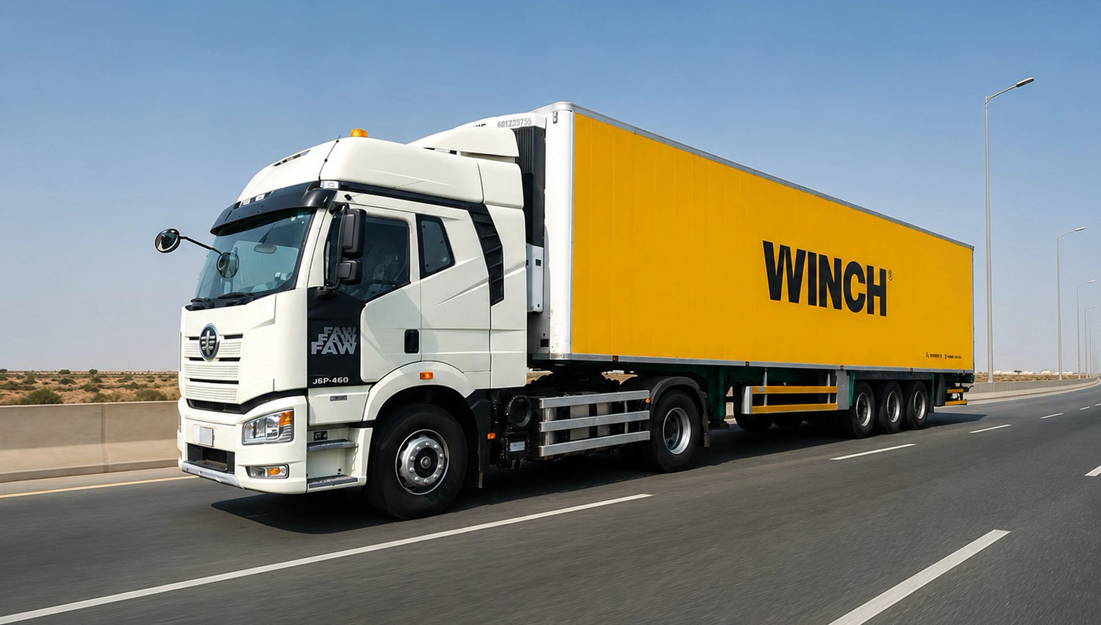 A white FAW tractor unit hauling a yellow WINCH-branded box trailer along a two-lane desert highway in flat daylight.