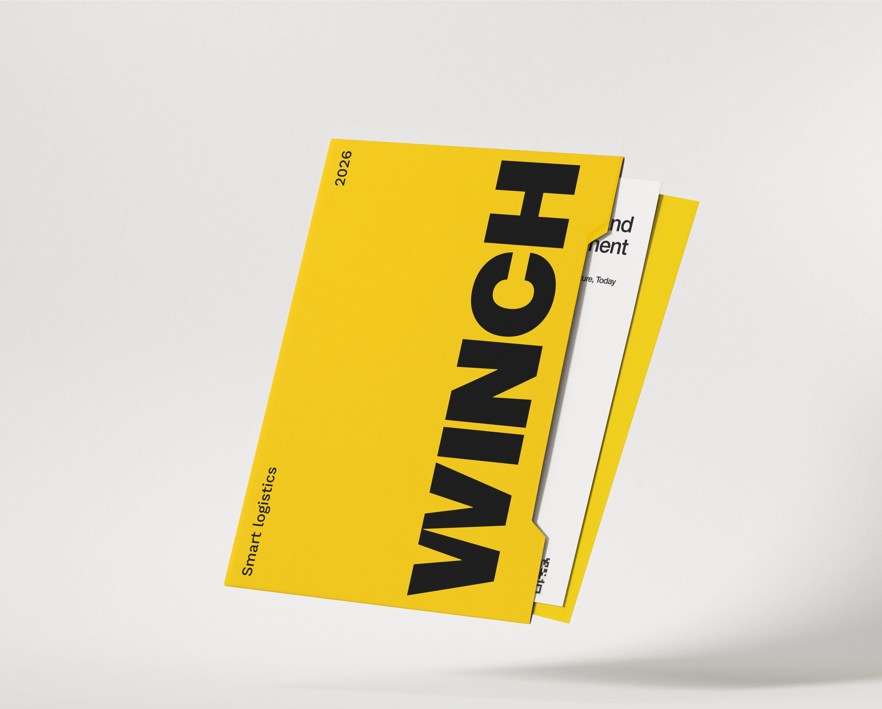 A yellow WINCH presentation folder floating at an angle on a soft grey ground, its cover carrying the vertical black WINCH wordmark with 2026 and Smart logistics set rotated beside it, and a white insert sheet and a yellow sheet protruding from the right edge.